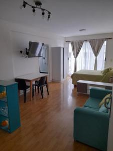 ein Wohnzimmer mit einem Bett, einem Sofa und einem Tisch in der Unterkunft Carlos Gardel Tango Studio in Buenos Aires