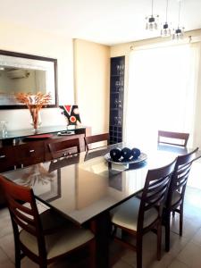 a dining room with a table with chairs and a mirror at HERMOSO DÚPLEX DE CATEGORÍA COMPLETAMENTE EQUIPADO in Cordoba