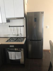 a kitchen with a stainless steel refrigerator and a stove at Apartament Elbląg Wyczółkowskiego 10 in Elblag