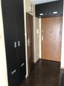 an empty room with black cabinets and a door at Apartament Elbląg Wyczółkowskiego 10 in Elblag