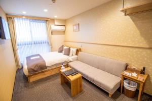 una camera d'albergo con un letto e un divano di Stay SAKURA Kyoto Shijo Karasuma a Kyoto