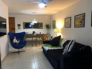 a living room with a couch and a dining room at Apartamento Praia Grande in Arraial do Cabo