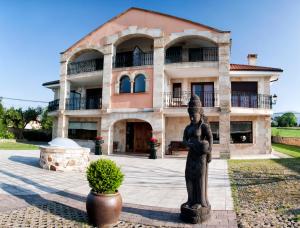 una grande casa con una statua davanti di Spa Rural Mies de Rubayo a Rubayo