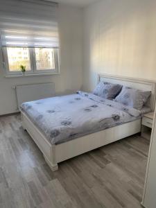 a bedroom with a large bed with white sheets and pillows at Apartmani Milić Banja Koviljača in Banja Koviljača