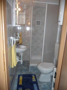 y baño con aseo, lavabo y ducha. en Apartments More, en Kaštela