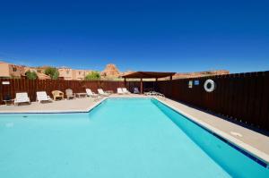 a blue swimming pool with chairs and a fence at Castle View #3368 in Moab