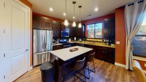 a kitchen with wooden cabinets and a island with stools at Entrada at Moab #640 in Moab