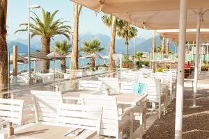 
a patio area with chairs, tables and umbrellas at The Beachfront Hotel Adult Only 16 Plus in Marmaris
