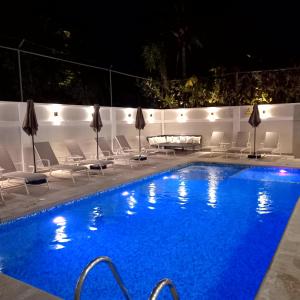 a swimming pool at night with chairs and a table at Villas Frida Kahlo in Bucerías