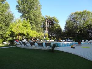 a group of chairs sitting next to a swimming pool at Hotel Playa Blanca in Duna Verde