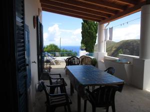 una mesa y sillas en un balcón con vistas al océano en Pomelia, en Lipari