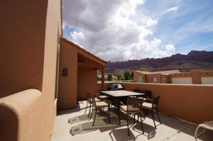a patio with a table and chairs on a balcony at Krystal Kiva #K4 in Moab
