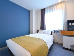 pokój hotelowy z łóżkiem i oknem w obiekcie FLEXSTAY INN Hakodate Station w mieście Hakodate