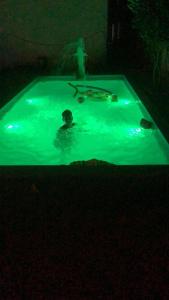 a person in a swimming pool at night at Apartamento encantador in Itapoa