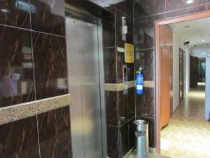 a bathroom with a tile wall with a bottle on it at The Amazing Inn in Singapore