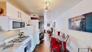 a kitchen with white appliances and red chairs at Moab Flats #7 in Moab