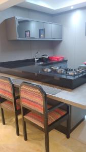 Apartamento/Studio centro florianopolis في فلوريانوبوليس: مطبخ مع كونتر أسود وطاولة مع موقد
