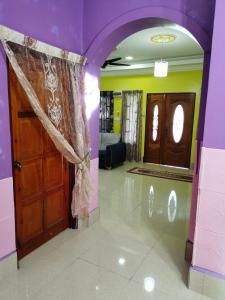a room with purple walls and a door and a mirror at Homestay Che Wan Dua in Kuantan