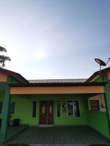 a green house with a door and a porch at Homestay Che Wan Dua in Kuantan