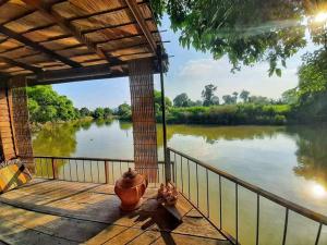 a view of a river from the porch of a house at Rustic​ Charm​ Suphan​ in Ban Tha Pong