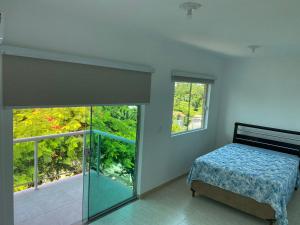 a bedroom with a bed and a large window at Ferias floripa 122 in Florianópolis