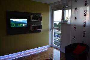 ein Wohnzimmer mit einem TV und einem Fenster in der Unterkunft Apartments Zadar 4 You in Zadar