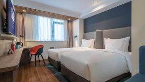 a hotel room with two beds and a desk at Holiday Inn Express Qingdao City Center by IHG in Qingdao +45 photos