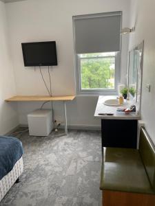 ein Schlafzimmer mit Schreibtisch, Fernseher und Bett in der Unterkunft Parkes Hotel in Parkes