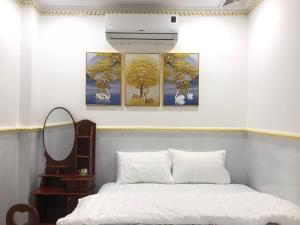 1 dormitorio con 4 pinturas en la pared en Khách Sạn Mỹ Hằng, en Soc Trang