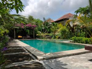 a swimming pool in front of a house at Pier26 Bali Homestay in Nusa Dua