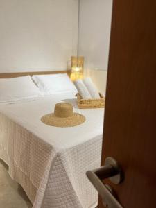 a straw hat is sitting on a bed at Patacho Beach - Milagres - Rota Ecológica in Pôrto de Pedras