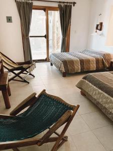 um quarto com duas camas e uma rede de descanso em Cabañas Laguna em Isla Aguada