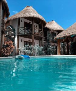 a resort with a swimming pool in front of a building at Cabañas Laguna in Isla Aguada