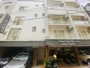 a white building with cars parked in front of it at Greens Suite - Business Class Hotel - Opposite Ripon Building in Chennai