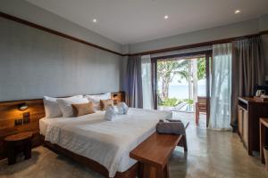 a bedroom with a large white bed and a table at Banana Fan Sea Resort in Chaweng +37 photos