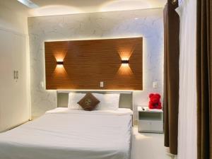 a bedroom with a bed with two lights above it at Poetic Hue Hotel & Spa in Hue