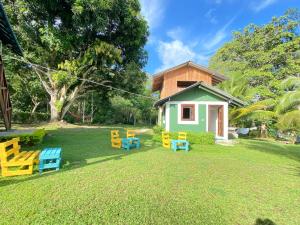 a small house with yellow and blue benches in the yard at Hostal Portal Del Sol in Capurganá
