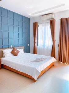 a bedroom with a bed and a blue wall at Poetic Hue Hotel & Spa in Hue