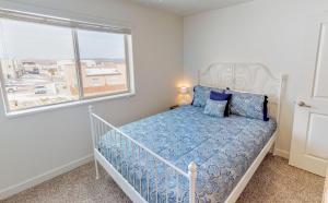 a bedroom with a bed with blue sheets and a window at Red Cliff Condos #6i in Moab