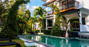 an exterior view of a house with a swimming pool at Aqua Suites in Wok Tum
