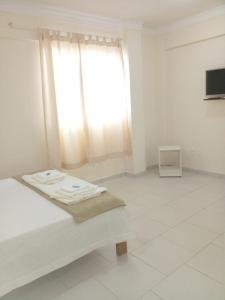 ein weißes Zimmer mit einem Bett und einem Fenster in der Unterkunft Riachuelo Hotel in Resende