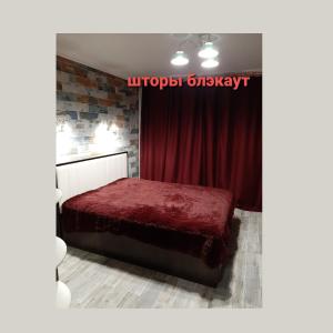 ピャチゴルスクにあるNiNA - трехкомнатная квартираのベッドルーム1室(赤いベッド1台、赤いカーテン付)