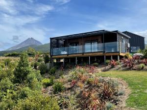 a house on a hill with a mountain in the background at Mangorei Heights - New Plymouth in New Plymouth