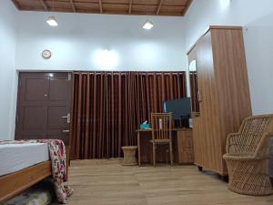 a bedroom with a bed and a cabinet and a tv at Beach Nest in Kannur