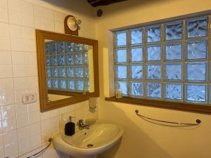 ein Bad mit einem Waschbecken, einem Spiegel und einem Fenster in der Unterkunft La casa sul comó in Neapel