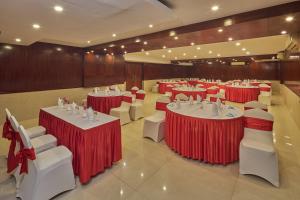 a banquet hall with red and white tables and chairs at Tulip Inn Koramangala Bangalore in Bangalore