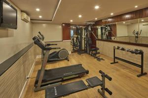 a fitness room with a gym with a treadmill and weights at Tulip Inn Koramangala Bangalore in Bangalore