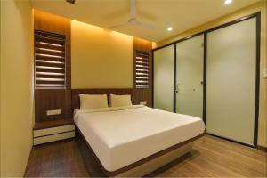 a bedroom with a white bed and some windows at FabHotel Eros 282 in Kolkata