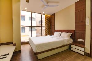 a bedroom with a bed and a large window at FabHotel Eros 282 in Kolkata