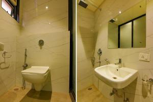 a bathroom with a sink and a toilet and a mirror at FabHotel Eros 282 in Kolkata